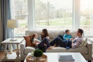 A man and woman with their two young children on a cream couch